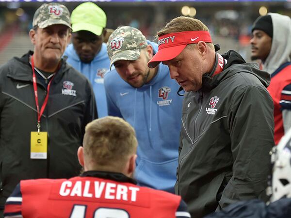 Liberty coach Hugh Freeze, right, talks to quarterback Stephen “Buckshot” Calvert during his team's game against New Mexico State on Nov. 30.