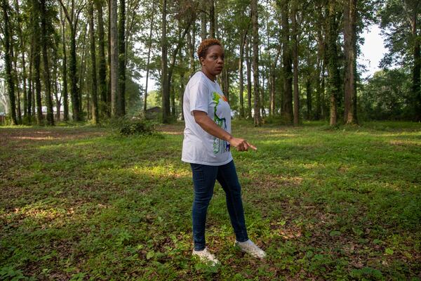 07/26/2021 — Newnan, Georgia — Ayisat Idris-Hosch, president of Newnan’s African American Alliance, points out impressions in the ground that represent unmarked burial plots at the Farmer Street Cemetery in Newnan, Monday, July 26, 2021. (Alyssa Pointer/Atlanta Journal-Constitution)