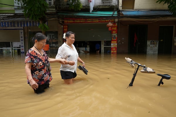 FILE - People wade in a flooded street in the aftermath of Typhoon Yagi, in Hanoi, Vietnam, on Sept. 12, 2024. (AP Photo/Hau Dinh, File)