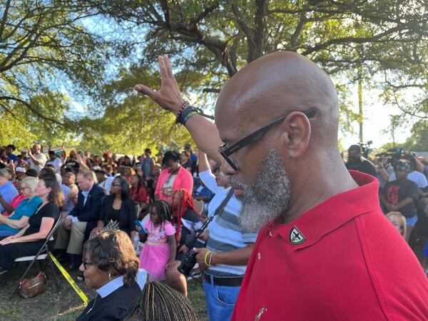 A man holds up his hand during a vigil on Sunday for the victims of Saturday's racially motivated shooting in Jacksonville.