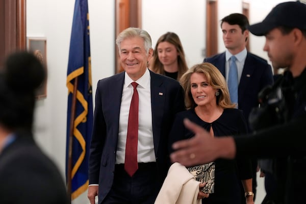 Dr. Mehmet Oz, left, President Donald Trump's pick to lead the Centers for Medicare and Medicaid Services, arrives with his wife Lisa Oz before testifying at his confirmation hearing before the Senate Finance Committee, on Capitol Hill in Washington, Friday, March 14, 2025. (AP Photo/Ben Curtis)