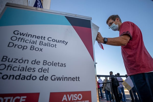 A voter places his absentee ballot inside a drop box on the second day of early voting at the Gwinnett County Voter Registration and Elections building on Oct. 13, 2020, in Lawrenceville, Georgia. An auditor from Gwinnett County, Mark Andrews, who was falsely accused of election fraud in the film "2000 Mules" is suing the movies makers, Dinesh D'Souza and True the Vote, alleging they lied to advance a phony narrative at his expense. (Alyssa Pointer/Atlanta Journal-Constitution/TNS)