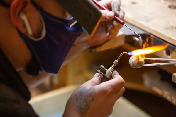 
Bench jeweler Sebastian Duran resizes a ring at the Gem Shopping Network's Duluth headquarters on Nov. 16, 2020. STEVE SCHAEFER / SPECIAL TO THE AJC 