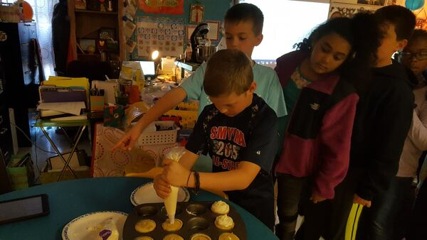 Cameron Silva, 9, learns to decorate a Tiramisu cupcake in preparation for his fourth grade class’s Kitchen Kids Cafe project. 