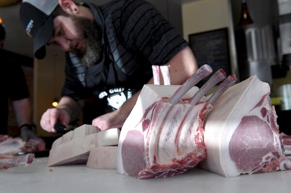 Bryan Butler, winner of the best butcher in Austin, Texas, cuts pork chops as he and members of Team USA for the World Butchers' Challenge 2018 do a practice run at Taylor's Meat Market on Monday, Aug. 7, 2017. (Hector Amezcua/Sacramento Bee/TNS)