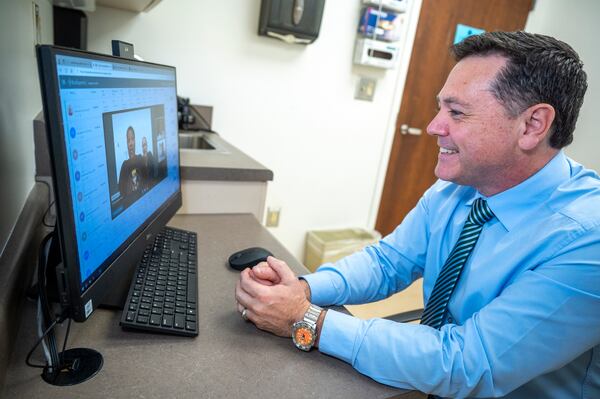 Dr. Matt Lyon, director of the Center for Telehealth at the Medical College of Georgia in Augusta, talks with his patient, Asia Daniels, during a telemedicine session at the Medical College of Georgia in Augusta, Ga., Monday morning November 20, 2023.  Lyon directs a telemedicine program at the Augusta hospital now known as Wellstar MCG Health. (PHOTO courtesy of Wellstar MCG Health by Michael Holahan)