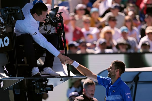 Novak Djokovic of Serbia shakes hands with chair umpire James Keothavong after retiring from his semifinal match against Alexander Zverev of Germany at the Australian Open tennis championship in Melbourne, Australia, Friday, Jan. 24, 2025. (AP Photo/Ng Han Guan)