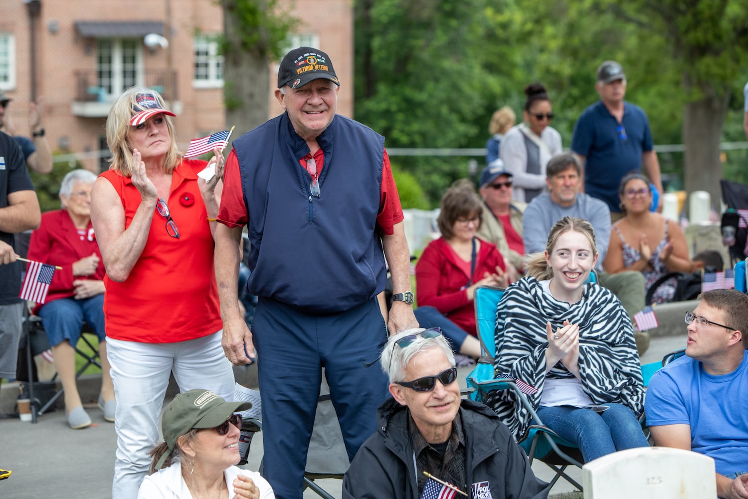 Standing for the Armed Forces Medley and representing the Marines, Julie Porter, left, supports her veteran Marine husband, Ken Porter, during the 77th annual Memorial Day Observance at the Marietta National Cemetery on Monday, May 29, 2003.  (Jenni Girtman for The Atlanta Journal-Constitution)