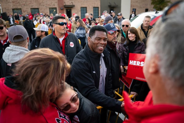 Herschel Walker, center, poses for photos during a campaign stop in Peachtree City, Ga., on Nov. 13, 2022.  (Nicole Craine/The New York Times)