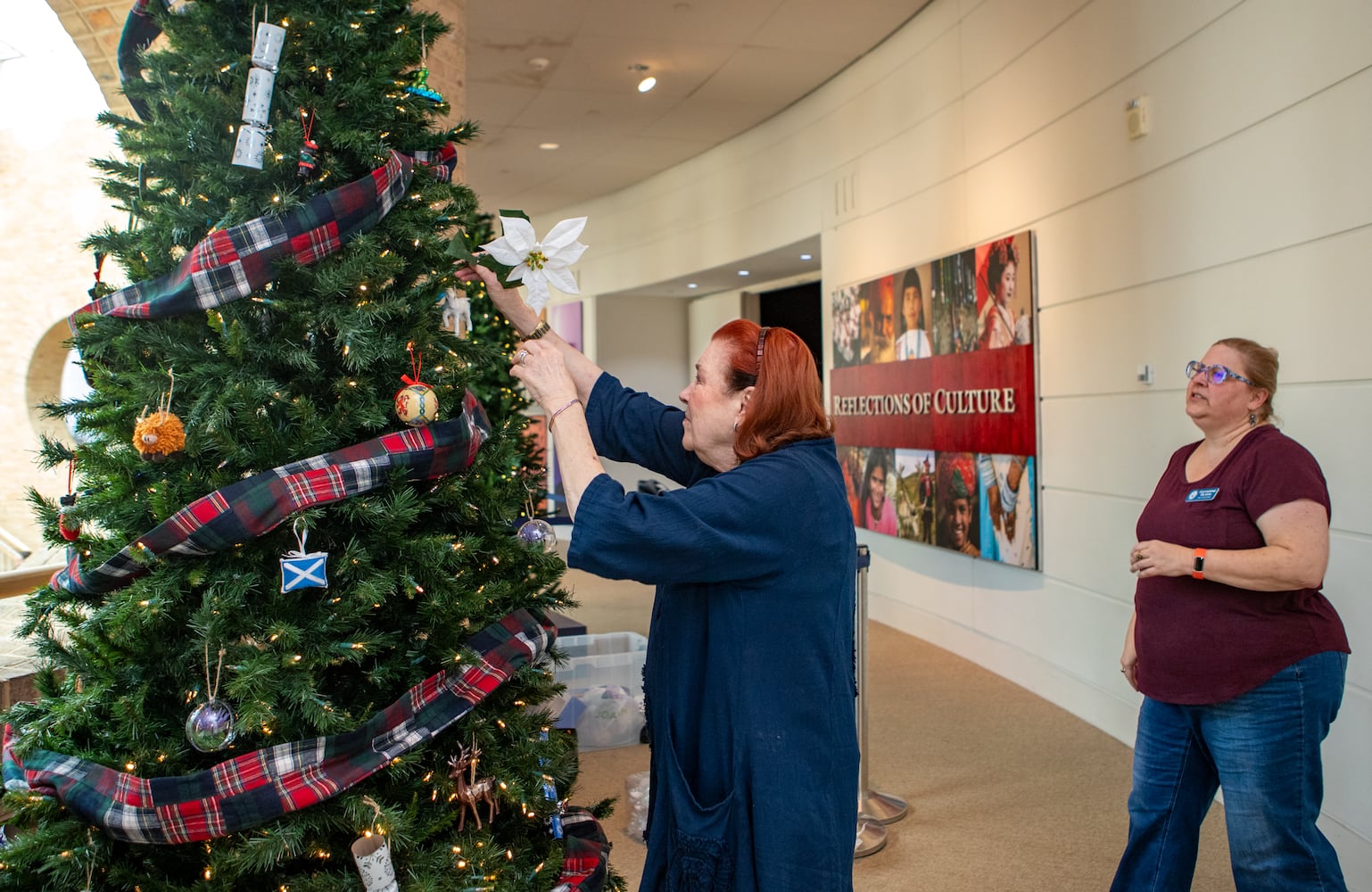 Fernbank Museum prepares for the 15th annual "Winter Wonderland" exhibit where Atlanta cultural partners, including President of St. Andrews Society Catherine Olson, right, and her mother Caren Miears decorate the Scottish tree on Saturday, Nov 16, 2024 . Exhibit opens November 23 and runs through January 12, 2025. (Jenni Girtman for The Atlanta Journal Constitution)