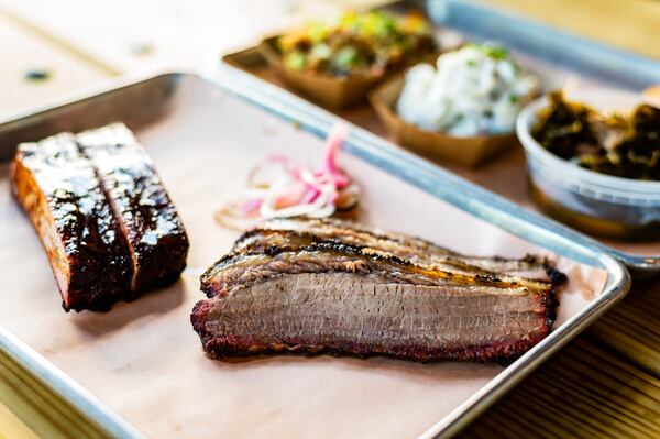 A two-meat plate of St. Louis-style pork ribs and beef brisket with three sides and cornbread. The two-meat plate typically includes two sides. CONTRIBUTED BY HENRI HOLLIS