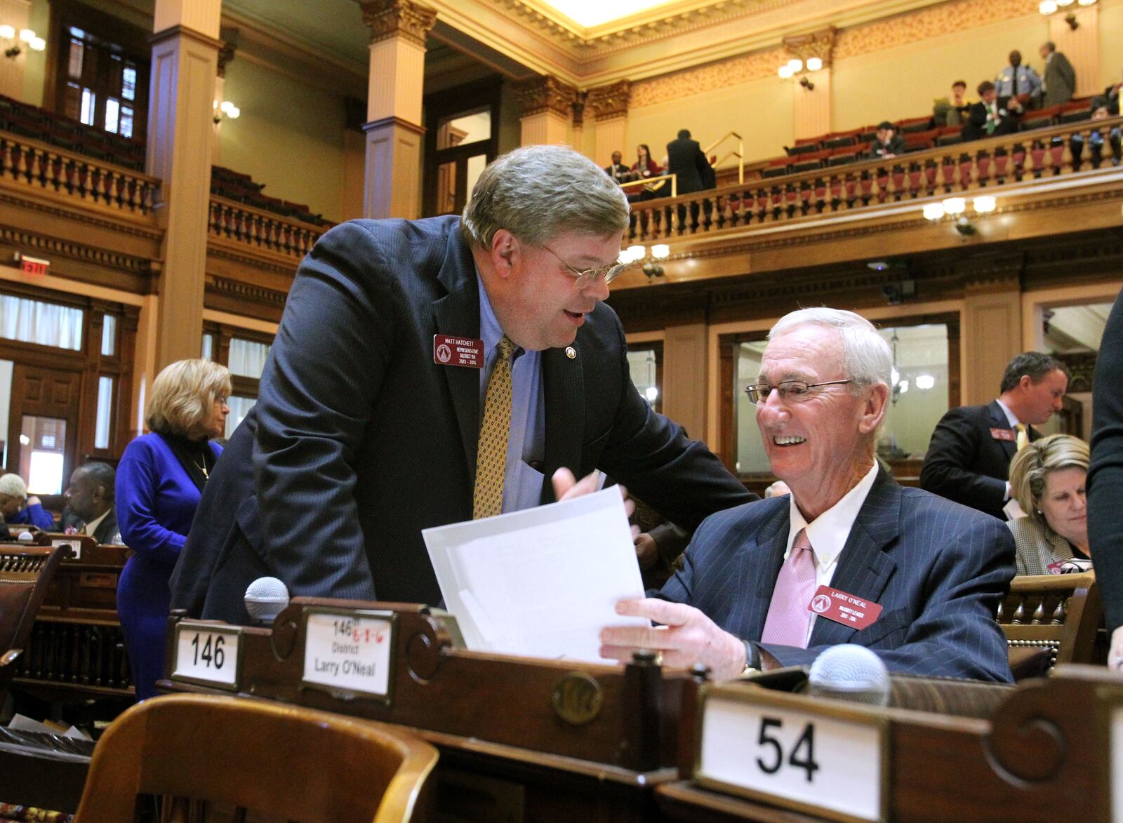 Rep. Matt Hatchett, R-Dublin, left, talks with House Majority Leader Rep. Larry O'Neal, R-Bonaire, as they celebrate the passing of Senate Bill 24.