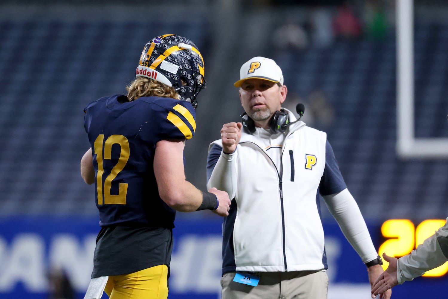 Prince Avenue Christian coach Greg Vandagriff, facing, celebrates with his son and quarterback Brock Vandagriff (12) after a touchdown in the second half of their 41-21 win against Trinity Christian during the Class 1A Private championship at Center Parc Stadium Monday, December 28, 2020 in Atlanta, Ga.. JASON GETZ FOR THE ATLANTA JOURNAL-CONSTITUTION