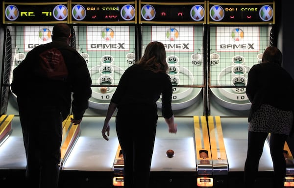 Players compete in a game of skee ball at Game-X. CURTIS COMPTON / CCOMPTON@AJC.COM