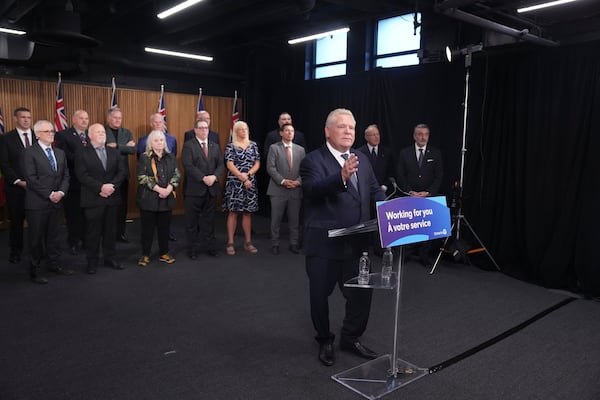 Ontario Premier Doug Ford speaks to members of the media as mayors from selected municipalities and government ministers look on the Queen's Park Legislature in Toronto on Thursday Dec. 12, 2024. (Chris Young/The Canadian Press via AP)