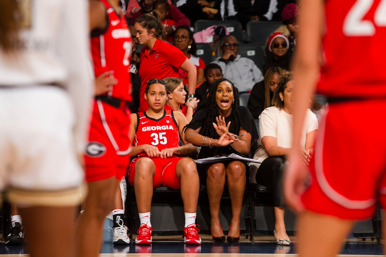 Bulldogs assistant coach Isoken Uzamere encourages UGA players during their game against Georgia Tech on Sunday in Atlanta. (CHRISTINA MATACOTTA / FOR THE ATLANTA JOURNAL-CONSTITUTION)