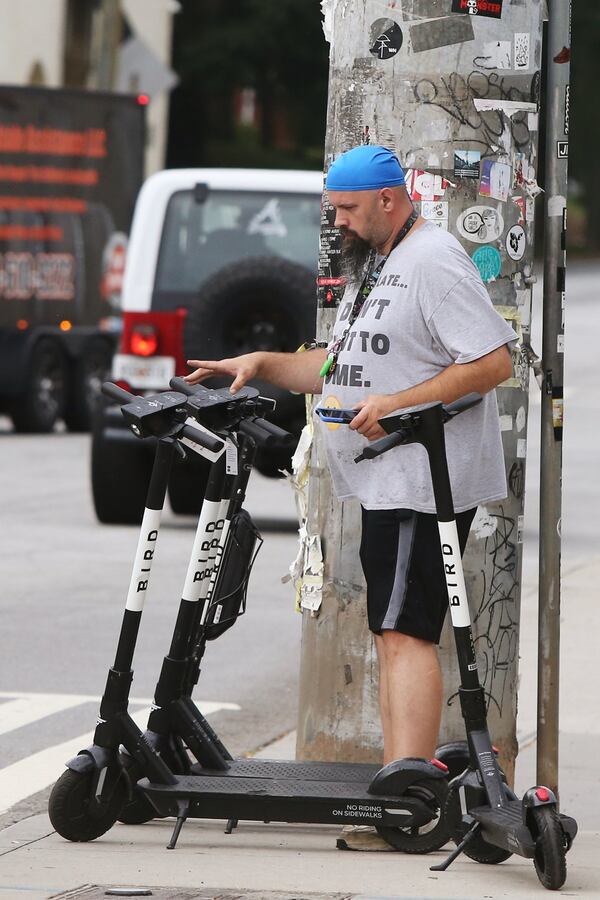 Greg Terrell, a charger for Bird, distributes Bird scooters along the Atlanta BeltLine and in Piedmont Park earlier this month. New safety measures, such as an 8 mph speed limit and designated parking areas, were installed along the Beltline. Christina Matacotta/Christina.Matacotta@ajc.com