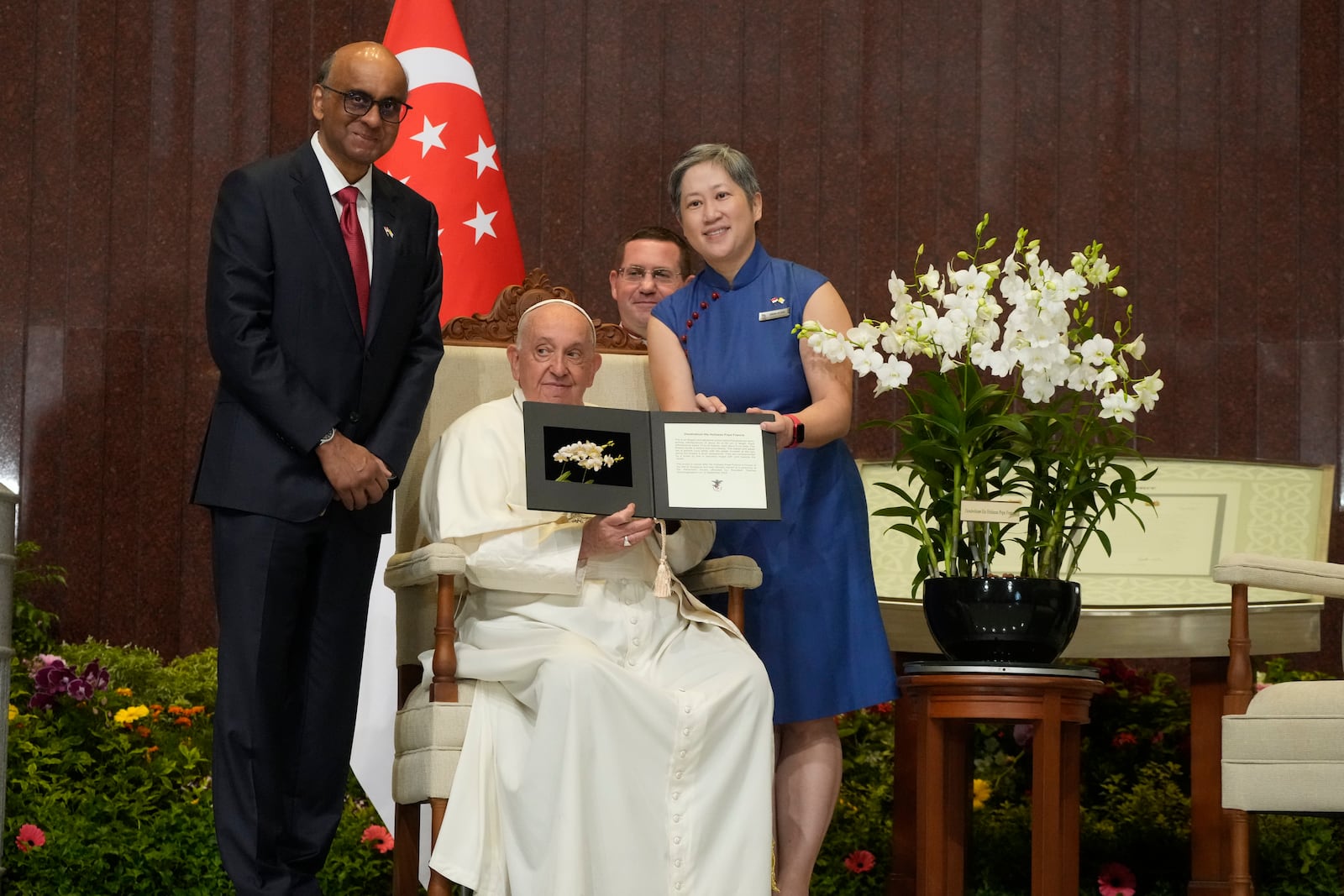 Chief Executive Officer of the Singapore's National Parks Board Hwang Yu-Ning, right, and Singapore's President Tharman Shanmugaratnam, left, present Pope Francis with a 'Dendrobium His Holiness Pope Francis', a specially bred orchid variety named after him in honor of his visit to Singapore during a welcome ceremony at the Parliament House in Singapore, Thursday, Sept. 12, 2024. Pope Francis flew to Singapore on Wednesday for the final leg of his trip through Asia, arriving in one of the world's richest countries from one of its poorest after a record-setting final Mass in East Timor. (AP Photo/Gregorio Borgia)