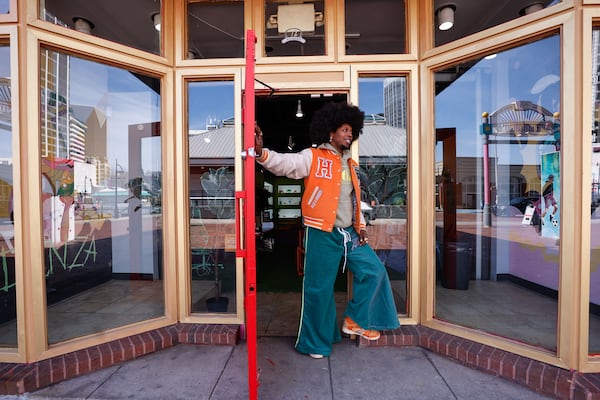 Atlanta rapper Trinidad James poses for a photo in front of his new boutique Hommewrk, located inside Underground Atlanta, on March 7. (Natrice Miller/AJC)