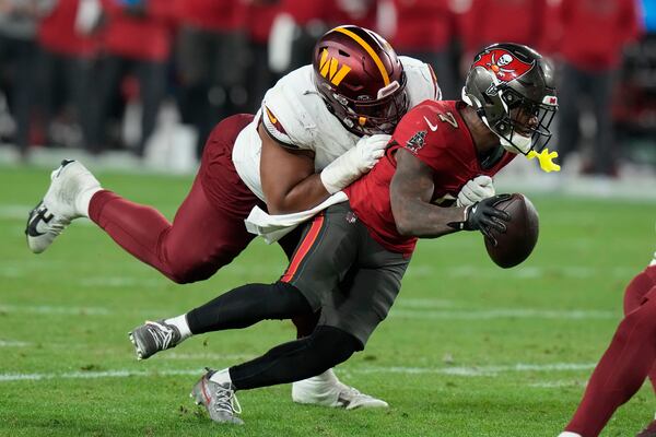 FILE- Tampa Bay Buccaneers running back Bucky Irving, right, runs against Washington Commanders defensive tackle Jonathan Allen during the second half of an NFL wild-card playoff football game in Tampa, Fla., Jan. 12, 2025. (AP Photo/Chris O'Meara, file)