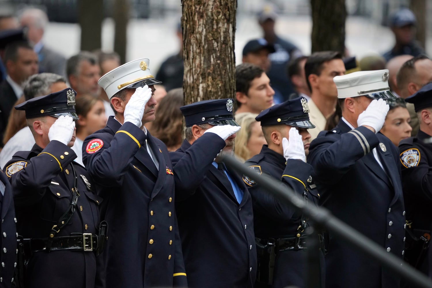 New York City police officers and firefighters salute during a ceremony to mark the 22nd anniverary of the terror attack on the World Trade Center at the 9/11 Memorial in lower Manhattan on Monday, Sept. 11, 2023. (Maansi Srivastava/The New York Times)