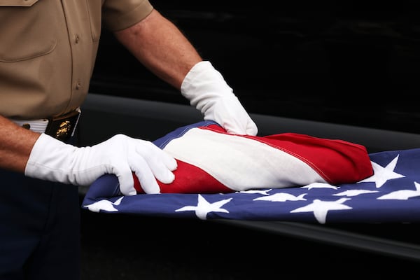 Richard Thomas, the folder, performs his precise triangular folding of the flag. Upon completion, his brother Charlie, the holder, tucks the remaining flag margin into the "pocket" formed by the "blue field" edge of the flag. (Courtesy of White County Color and Honor Guard/Tom Johnson)