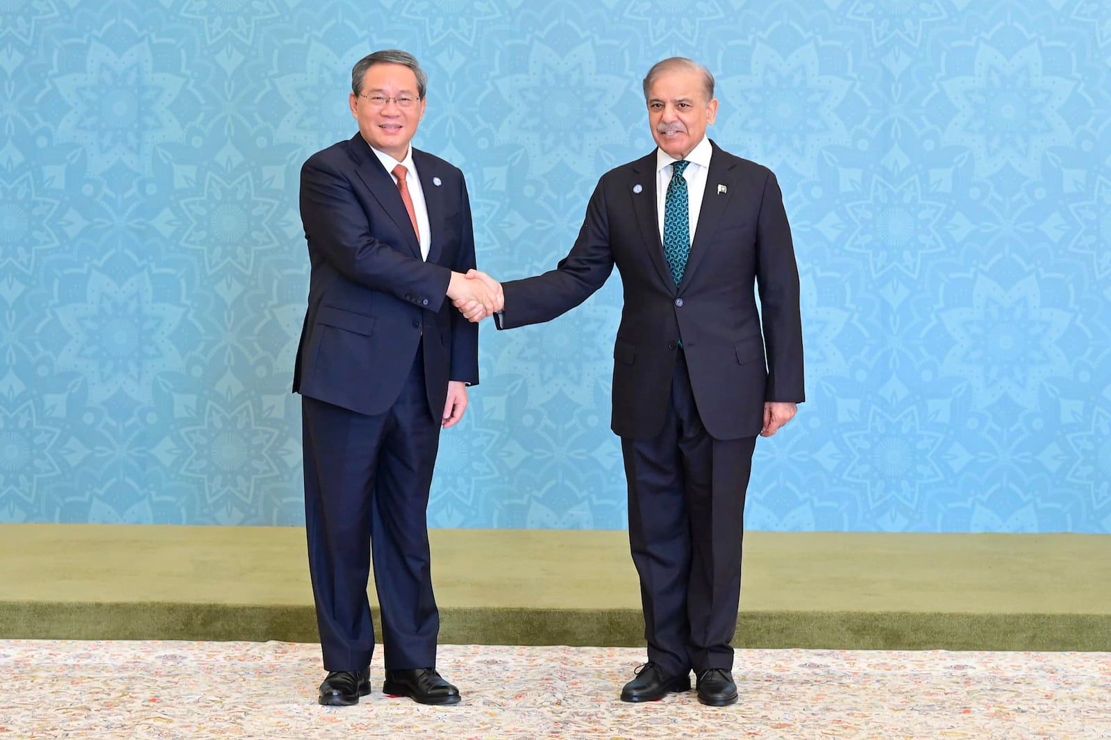 In this photo released by the Press Information Department, China's Premier Li Qiang, left, shakes hand with his Pakistani counterpart Shehbaz Sharif as he arrives to attend Shanghai Cooperation Organization (SCO) meeting, in Islamabad, Pakistan, Wednesday, Oct. 16, 2024. (Press Information Department via AP)