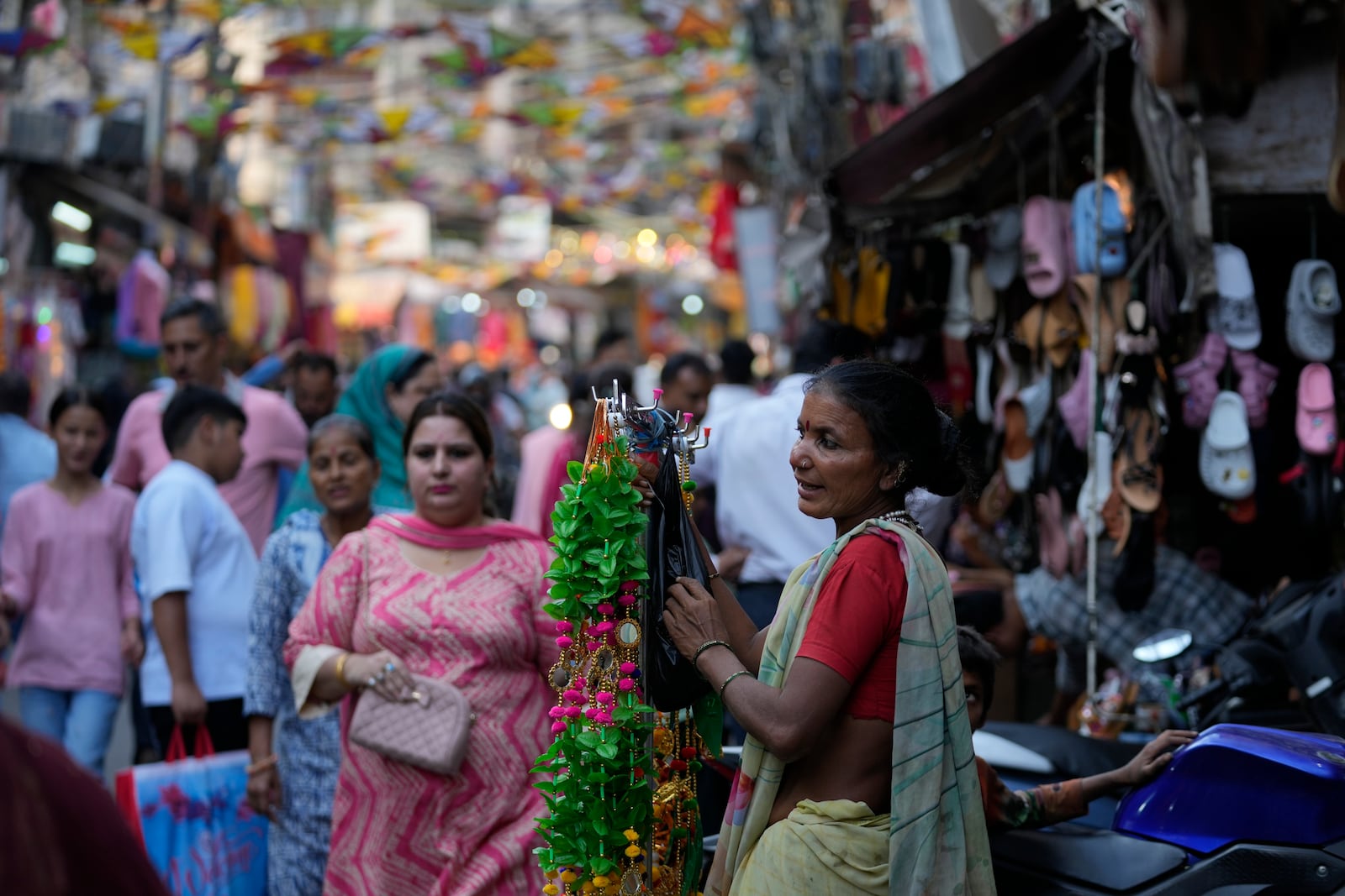 A woman sells artificial decorative flowers in market on the eve of the Diwali festival in Jammu, India, Wednesday, Oct.30,2024. Diwali is one of Hinduism's most important festivals, dedicated to the worship of the goddess of wealth Lakshmi. (AP Photo/Channi Anand)