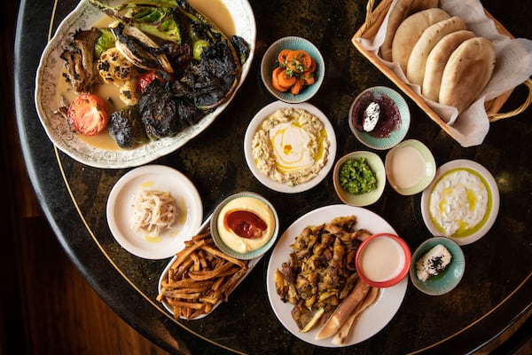 Nur Kitchen Mezze Plate, Seasonal Vegetable Plate, and Chicken Shawarma Platter with side of fries and mango aioli dipping sauce. (Mia Yakel for The Atlanta Journal-Constitution)