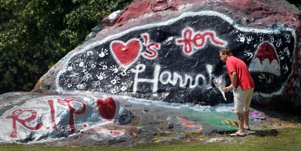 Jason Flanagan, who said he was a neighbor of Hannah Truelove, stopped by the rock to leave a bouquet of flowers in this AJC file photo. Gainesville high students painted a memorial to Hannah Truelove on "the Rock" near campus.