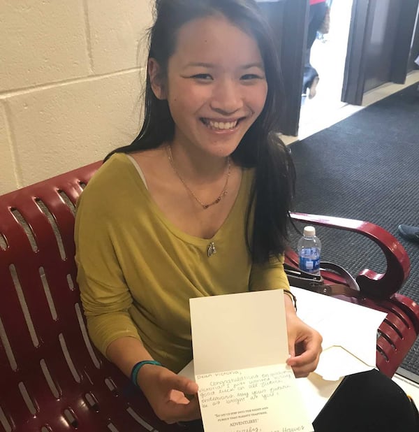 Brookwood High School senior Victoria Schmitt shows the card she received from classmate Megan Hawes. ERIC STIRGUS / ESTIRGUS@AJC.COM