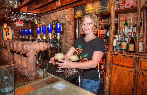 Erin Sargent, general manager at the Brick Store Pub, dispenses a couple of brews for patrons at the upstairs Belgian Bar section. CHRIS HUNT / SPECIAL