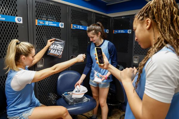 Columbia guards Mia Broom, left, and Riley Weiss show off some of the items they received in the locker room as Nasi Simmons records them for social media in Chapel Hill, N.C., Wednesday, March 19, 2025, before their First Four basketball game in the NCAA Tournament against Washington on March 20. (AP Photo/Nell Redmond)