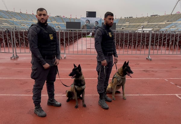 Hezbollah security members with their dogs stand at Beirut's City Sportive stadium, a day ahead of the funeral procession of Hezbollah leaders Sayyed Hassan Nasrallah and Sayyed Hashem Safieddine, in Beirut, Lebanon, Saturday, Feb. 22, 2025. (AP Photo/Hussein Malla)