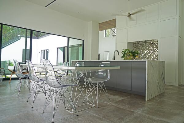 The kitchen of Treadwell and Lirette's home features a sleek, modern industrial style with natural lighting and custom cabinetry designed by Brian Watford. Courtesy of Helen Chen