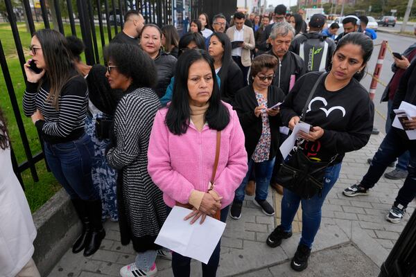 Gloria Camacho holds a notification stating her visa appointment was canceled, due to Colombian President Gustavo Petro's refusal to accept repatriation flights of Colombian citizens from the U.S., outside the U.S. embassy in Bogota, Colombia, Monday, Jan. 27, 2025. (AP Photo/Fernando Vergara)