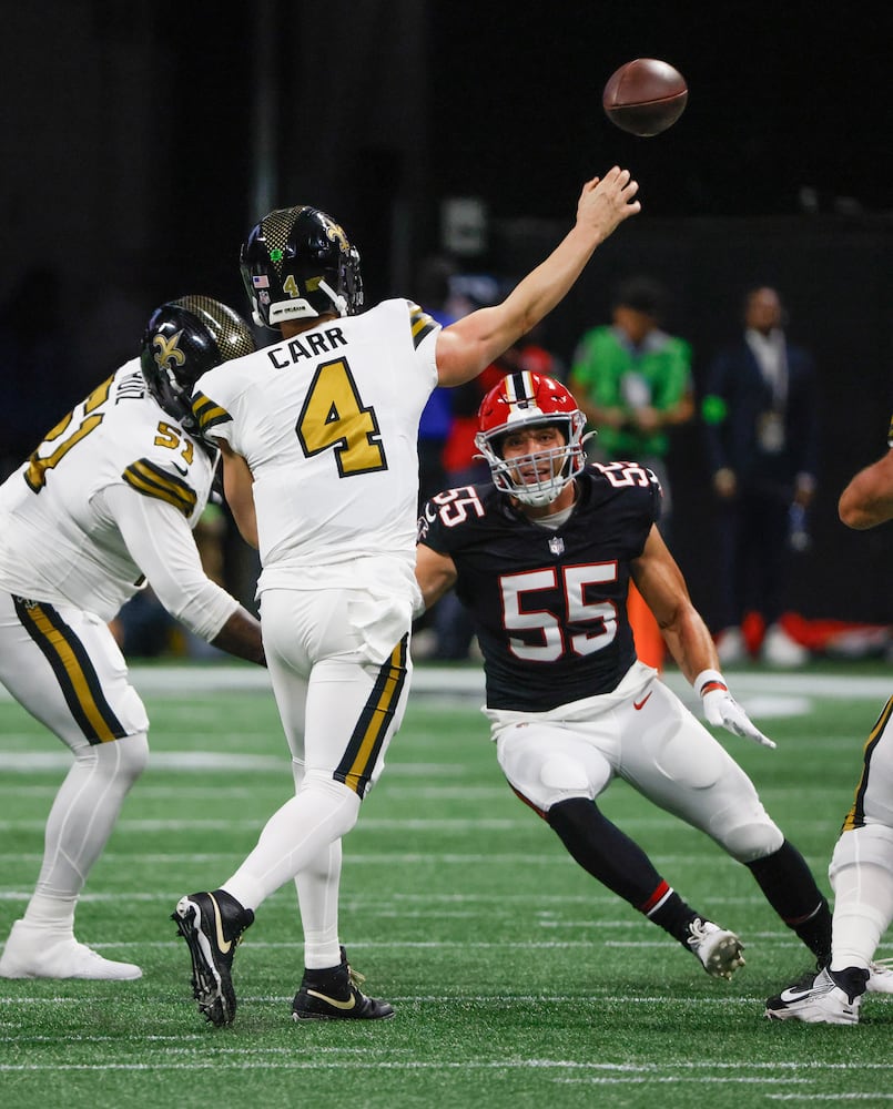 New Orleans Saints quarterback Derek Carr (4) throws under pressure from Atlanta Falcons linebacker Kaden Elliss (55) in an NFL football game in Atlanta on Sunday, Nov. 26, 2023.   (Bob Andres for the Atlanta Journal Constitution)