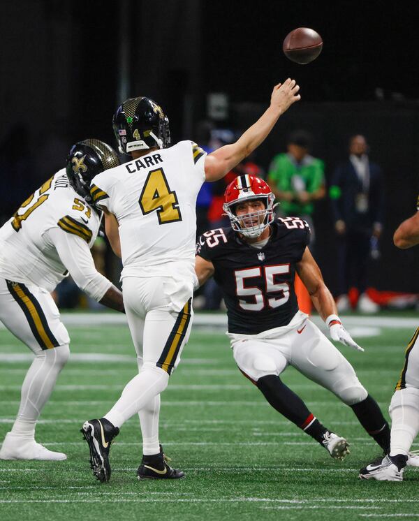 New Orleans Saints quarterback Derek Carr (4) throws under pressure from Atlanta Falcons linebacker Kaden Elliss (55) in a NFL football game between the Atlanta Falcons and the New Orleans Saints in Atlanta on Sunday, Nov. 26, 2023.   (Bob Andres for the Atlanta Journal Constitution)