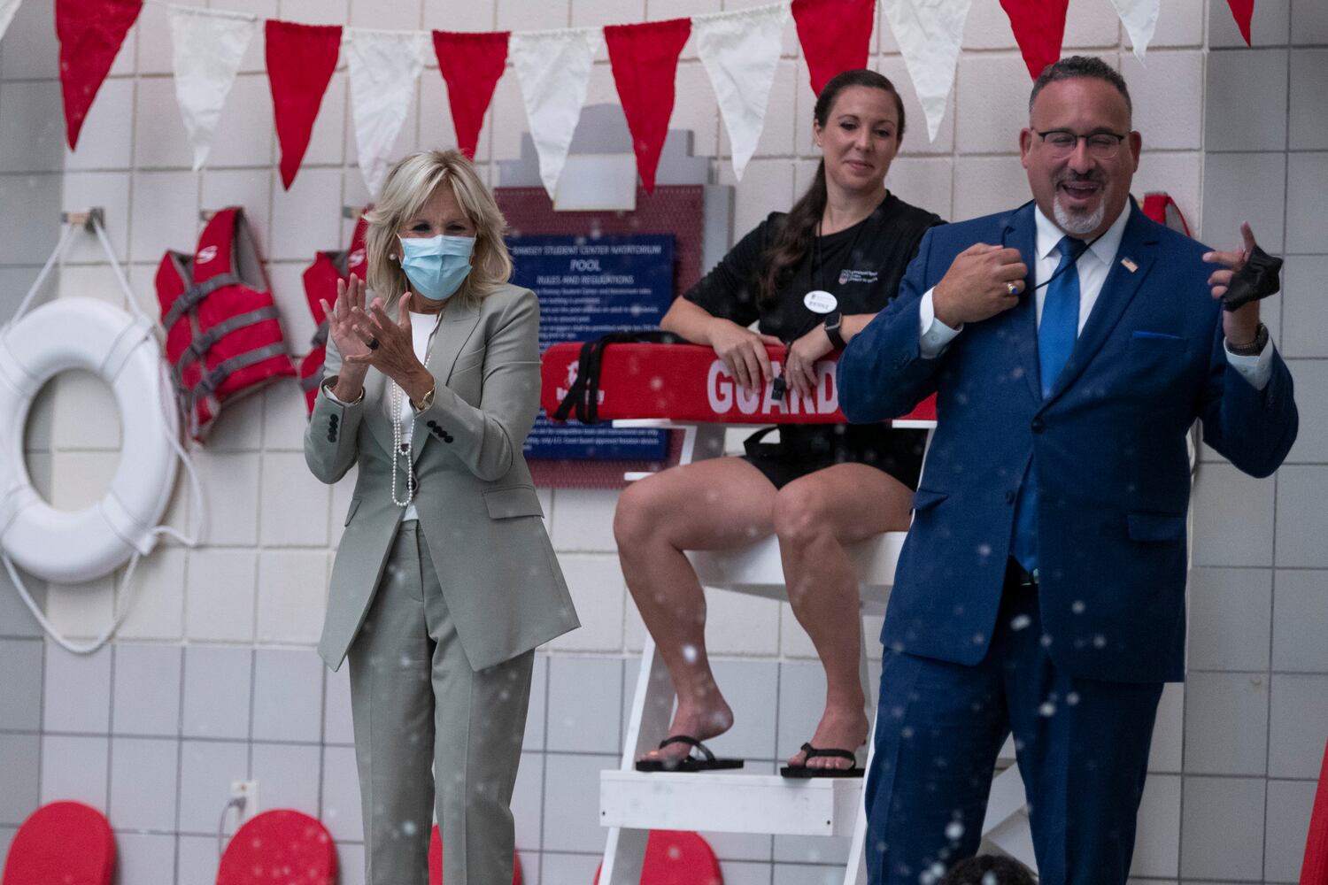 First Lady Jill Biden and Education Secretary Miguel Cardona cheer as students jump into a swimming pool while they visit a Horizons Atlanta summer learning program at the University of Georgia in Athens, Georgia on Thursday, July 21, 2022. The program serves students from Barnett Shoals Elementary School. (Chris Day/Christopher.Day@ajc.com)