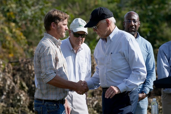 FILE - President Joe Biden, right, shakes hands with Buck Paulk, property manager of Shiloh Pecan Farm, after he spoke at the farm in Ray City, Ga., Oct. 3, 2024, as part of his trip to see areas impacted by Hurricane Helene. Looking on at right is Sen. Raphael Warnock, D-Ga. (AP Photo/Susan Walsh, File)