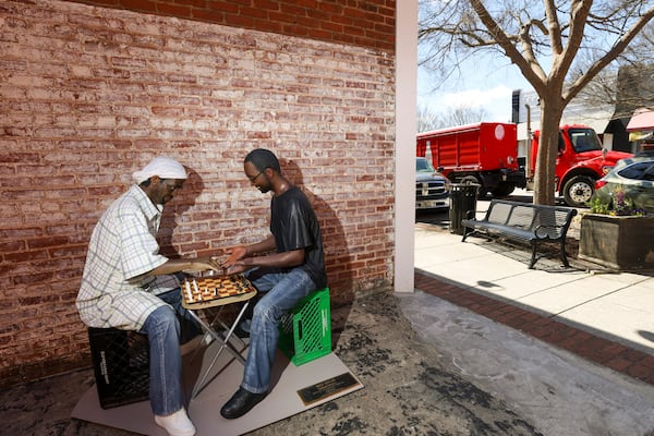 The life-size, realistic sculpture titled, “No Way!,” by Seward Johnson is shown, Thursday, March, 20, 2025, in Monroe, Ga. There are 10 statues that can be seen playing chess on a side street, playing music on the corner of the town green, hailing a cab holding an umbrella or a police officer writing a ticket in front of a parking space, among others. The sculptures will be in downtown Monroe until February 2026. (Jason Getz / AJC)