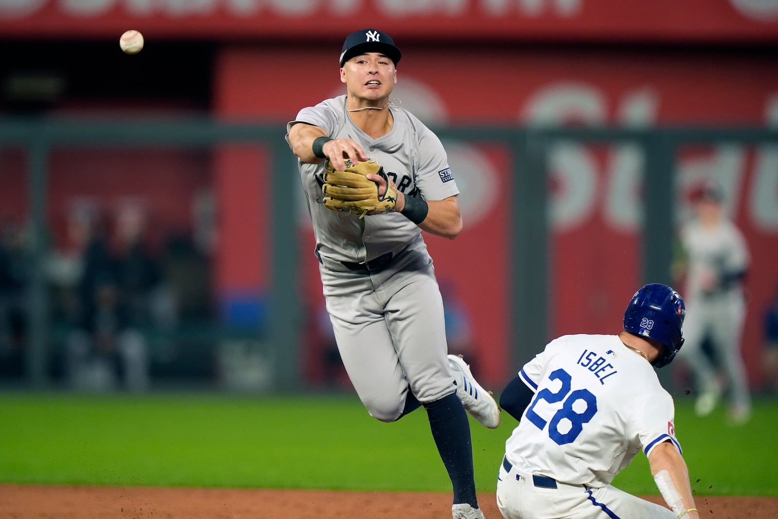 Kansas City Royals' Kyle Isbel (28) is out at second as New York Yankees shortstop Anthony Volpe during the third inning in Game 3 of an American League Division baseball playoff series Wednesday, Oct. 9, 2024, in Kansas City, Mo. The Royals' Michael Massey was out at first. (AP Photo/Charlie Riedel)