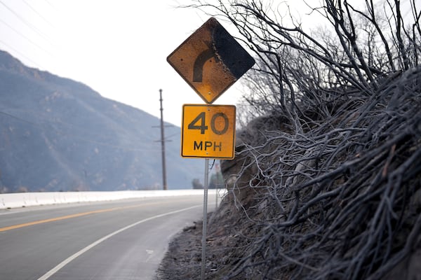 A road signed is burned after the Franklin Fire swept through Wednesday, Dec. 11, 2024, in Malibu, Calif. (AP Photo/Eric Thayer)