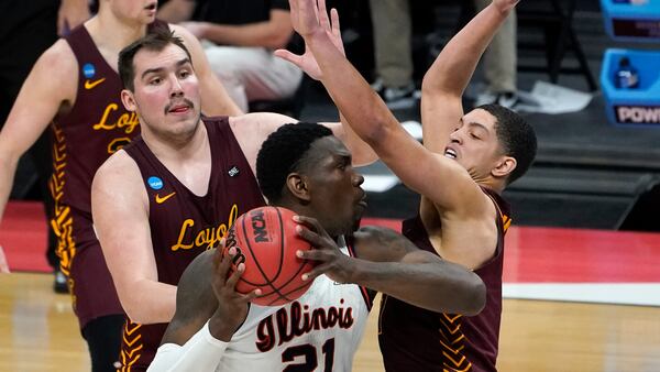 Illinois center Kofi Cockburn (21) is defended by Loyola Chicago center Cameron Krutwig (left) and Lucas Williamson during the first half their second round game at the NCAA Tournament Sunday, March 21, 2021, at Bankers Life Fieldhouse in Indianapolis. (Paul Sancya/AP)