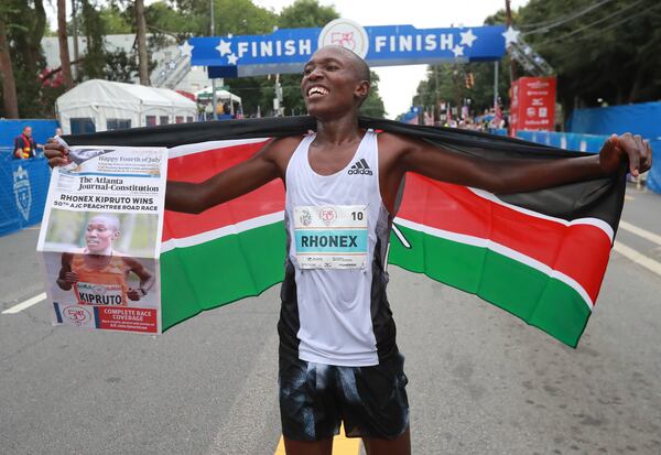 Rhonex Kipruto celebrates winning the 50th AJC Peachtree Road Race in record time on Thursday.  Curtis Compton/ccompton@ajc.com