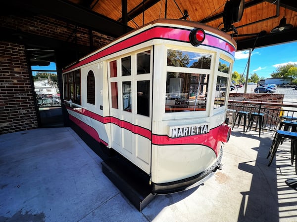 An antique trolley pokes out from the front facade of Marietta Square Market. Henri Hollis/henri.hollis@ajc.com