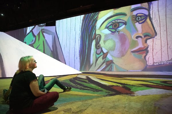 Rasa Raceviciute looks over the Imagine Picasso Atlanta: Immersive Art Exhibition on opening day at Pullman Yards in Atlanta Thursday, 17 2022.   STEVE SCHAEFER FOR THE ATLANTA JOURNAL-CONSTITUTION