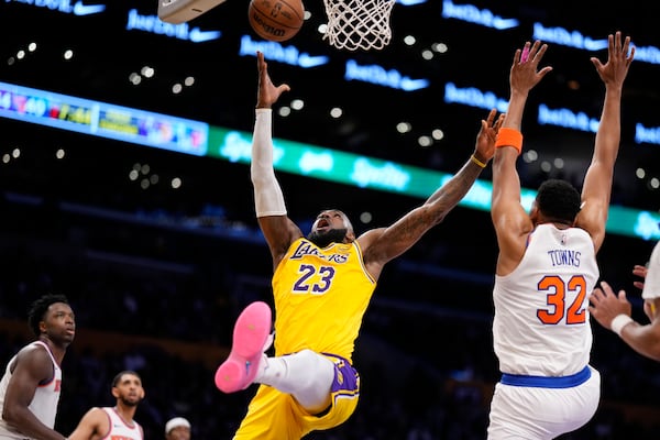 Los Angeles Lakers forward LeBron James (23) shoots as New York Knicks center Karl-Anthony Towns (32) defends during the first half of an NBA basketball game Thursday, March 6, 2025, in Los Angeles. (AP Photo/Mark J. Terrill)