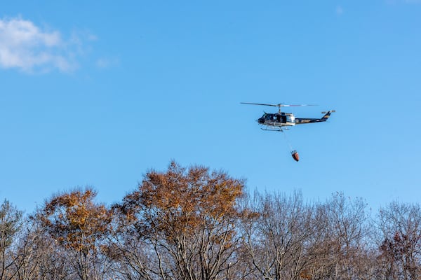 A New York State Police helicopter flies over the town of Awosting as seen from across Greenwood Lake, in Lakeside, N.J., Monday, Nov. 11, 2024. (AP Photo/Stefan Jeremiah)