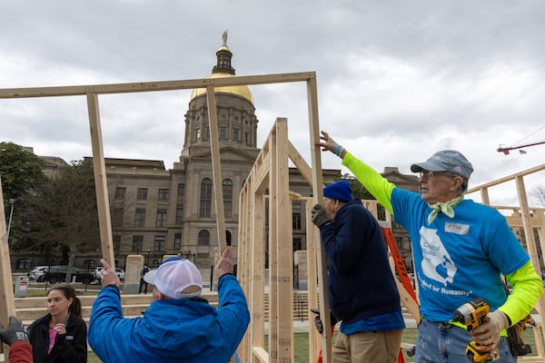 Habitat for Humanity volunteers worked at Liberty Plaza on Wednesday. The house frame was to be transported and used for a family home.